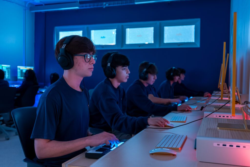 Students working on computers in a modern classroom, symbolizing digital talent development.