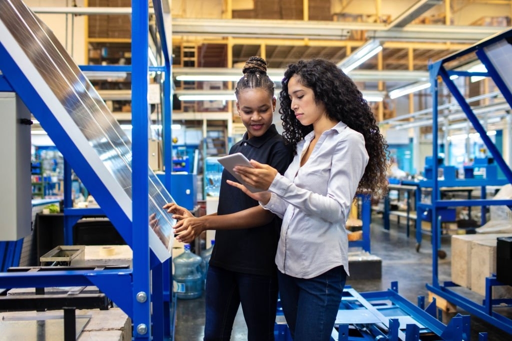 Dos mujeres trabajando en una planta de fabricación de paneles solares procedentes de solx-energy.com.