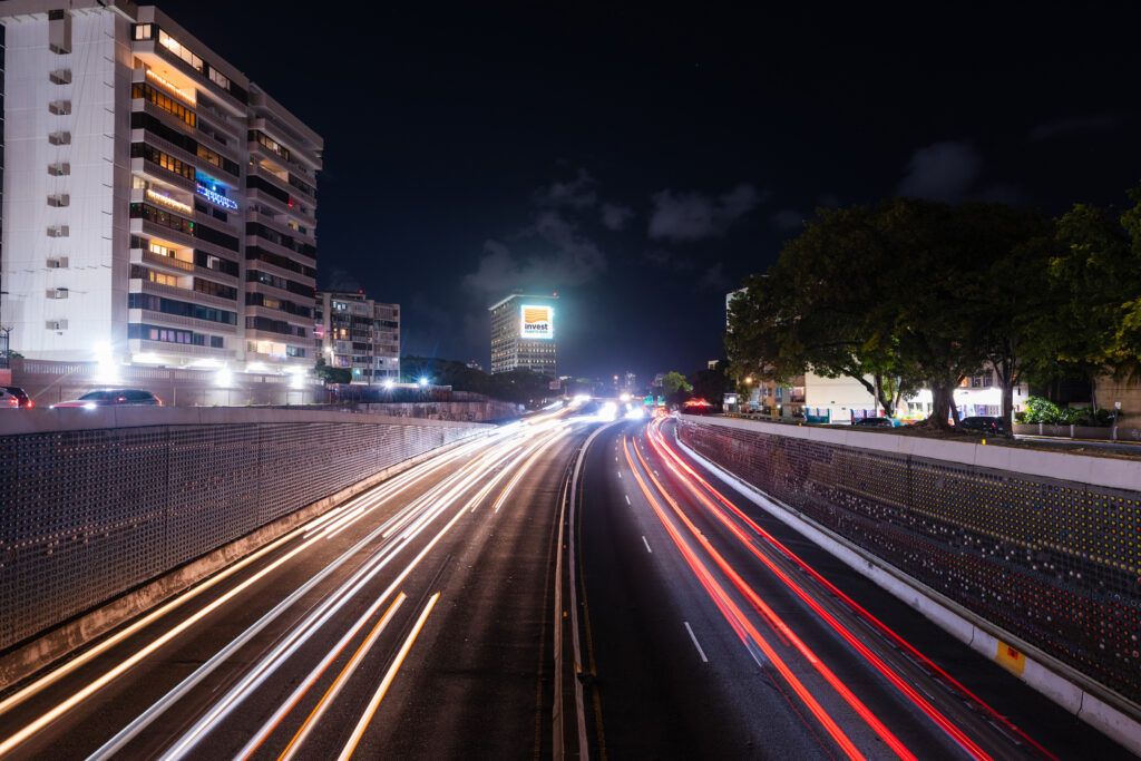 A vibrant night view of a highway in Puerto Rico with streaking car lights creating dynamic motion.